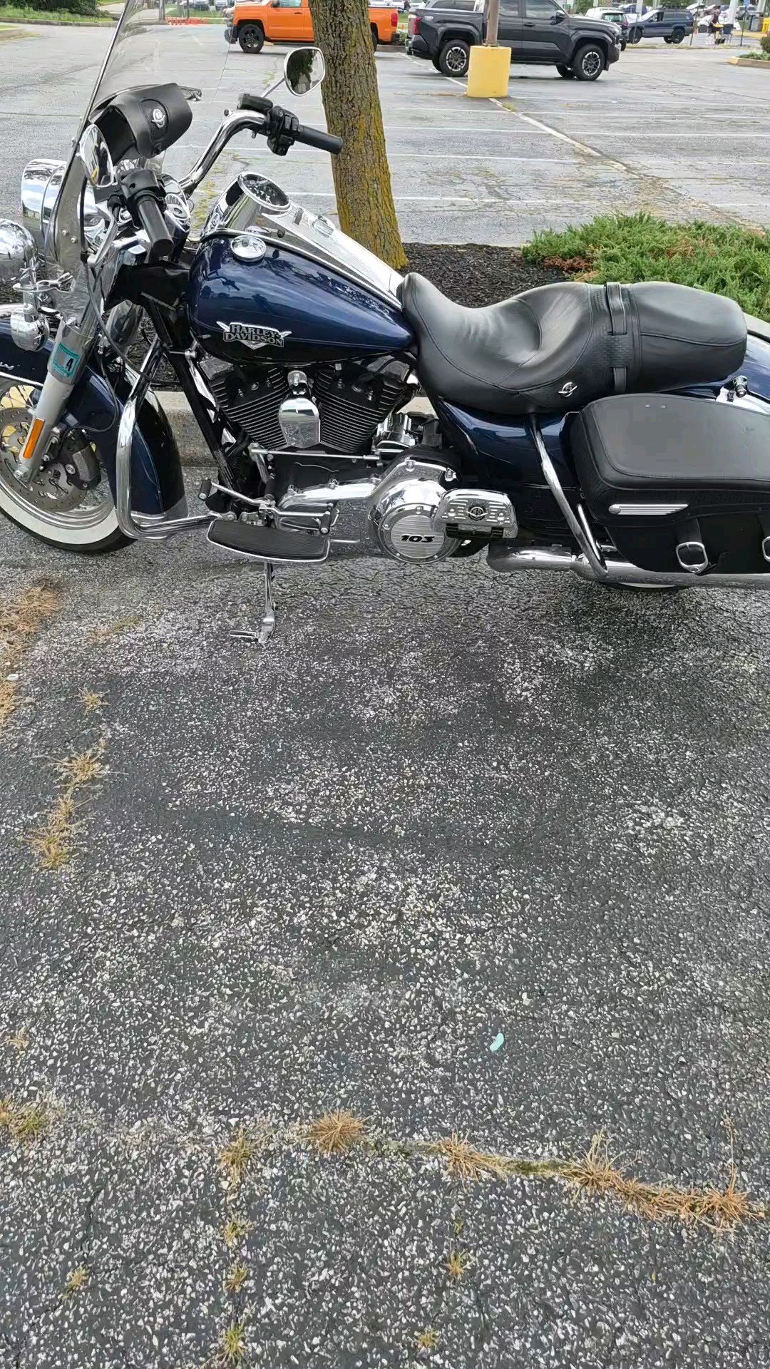 Blue Harley-Davidson Road King Classic 103 in a wet car park